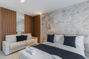 a bedroom with a white bed and a couch at Campo's Guest House Airport in Bari