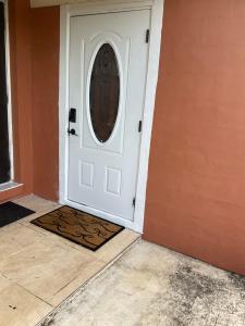a white door in a room with a door mat at Sweet Escape Cozy Studio in Fort Lauderdale