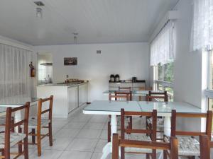 a kitchen and dining room with tables and chairs at Recanto Vó Eni in Gramado