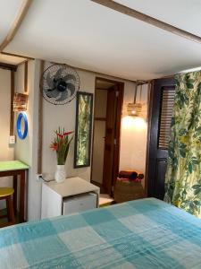 a bedroom with a bed and a fan on the wall at Casa Acquamarina in Atins