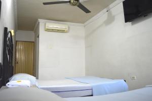 a hospital room with two beds and a ceiling fan at Hotel Terraza Girardot in Girardot