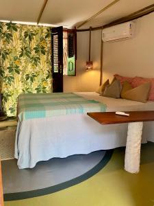 a bedroom with a large bed and a table at Casa Acquamarina in Atins