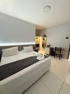 a bedroom with a large white bed and a desk at PUMMA BUDGET HOTEL in Canaã dos Carajás +18 photos