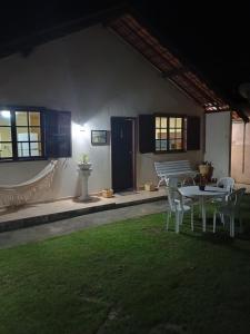 a patio with a table and chairs in a yard at Hospedagem do Rio in Nova Friburgo