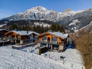 a house in the snow with mountains in the background at Schneeflocke Leogang in Leogang