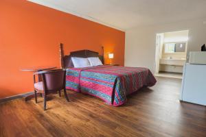 a bedroom with a bed with an orange wall at Vienna Travel Inn in Vienna