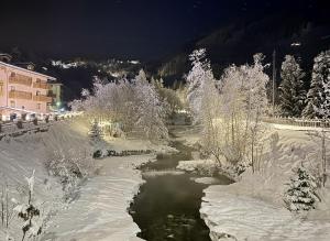 a river covered in snow next to a building at Cervinia House - Alpine Apartments & Chalet in Valtournenche