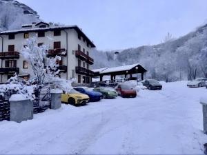 a group of cars parked next to a building in the snow at Cervinia House - Alpine Apartments & Chalet in Valtournenche +9 photos