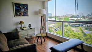 a living room with a couch and a large window at Sumaran II in Lima