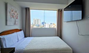 a bedroom with a bed and a large window at Sumaran II in Lima