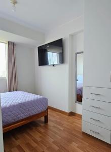 a bedroom with a bed and a dresser and a mirror at Sumaran II in Lima