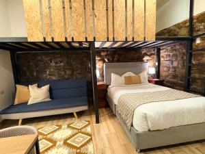 a bedroom with two bunk beds and a blue bench at Blacky Hostel and Apartments in Cusco