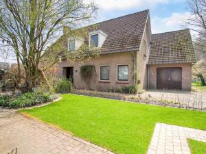 a house with a green lawn in front of it at Steenenburg Zicht in Nieuwkuijk