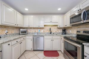 a white kitchen with white cabinets and appliances at Phoenix X 1504 condo in Orange Beach