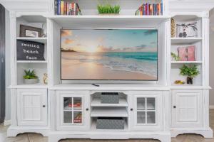a white entertainment center with a flat screen tv at Phoenix X 1504 condo in Orange Beach +55 photos