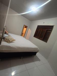 a small bedroom with a bed and a window at Eds pousada II in Juazeiro do Norte