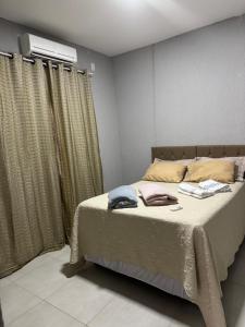 a bedroom with a bed and a air conditioner at Casa 2 temporada in Trindade