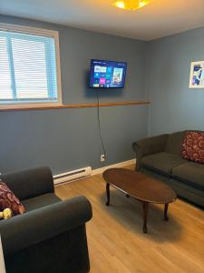 a living room with a couch and a table and a tv at The Gateway Suite in Fortune