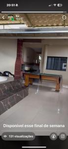 a view of a living room with a bench and a tv at Casa 2 temporada in Trindade