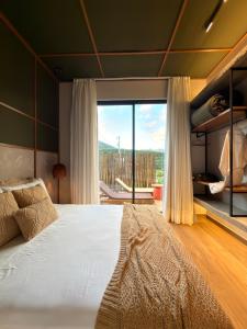 a bedroom with a large bed and a large window at Casa Cedro II in Espera Feliz +37 photos