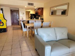 a living room with a couch and a table with chairs at Princesa C206 -Arcade Game-Experience Rocky Point- in Puerto Peñasco