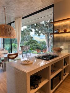 a kitchen with a large window and a table with chairs at Casa Cedro II in Espera Feliz