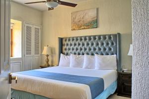 a bedroom with a large bed with a blue headboard at Princesa C206 -Arcade Game-Experience Rocky Point- in Puerto Peñasco +22 photos