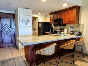 a kitchen with a counter and two bar stools at Princesa C206 -Arcade Game-Experience Rocky Point- in Puerto Peñasco