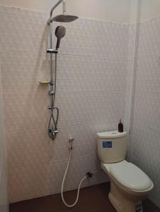 a bathroom with a shower with a toilet and a shower head at Hotel Shandira in Taliwang