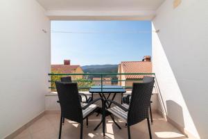 a table and chairs on a balcony with a view at Apartments with parking space Rabac, Labin - 6464 in Rabac