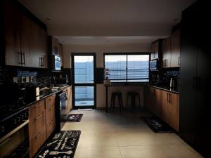 a kitchen with wooden cabinets and a view of the ocean at King Deluxe Cottage Room in Cape Town