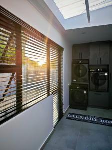 a kitchen with a washer and dryer next to a window at King Deluxe Cottage Room in Cape Town +24 photos