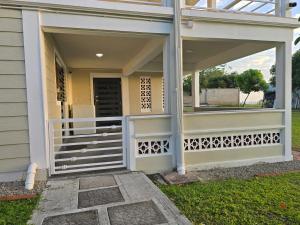 a front porch of a house with a white railing at Sunset Haven in Wallhouse