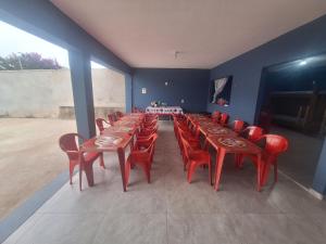 a large dining room with red chairs and tables at Diony in Brotas +6 photos
