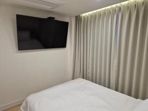a bedroom with a bed and a television on the wall at 광장관광호텔 in Pusan