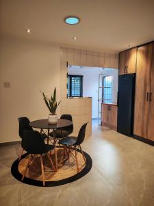 a dining room with a table and chairs and a kitchen at Stylish Studio Room with Shared Pool Near Table View Beach in Cape Town