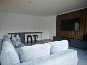 a living room with a white couch and a table at Stylish Studio Room with Shared Pool Near Table View Beach in Cape Town