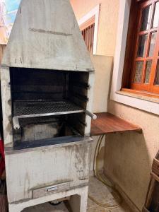 a barbecue grill sitting next to a window at Casa de hóspedes in Canoas