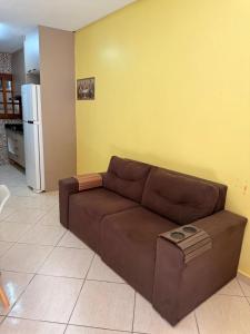 a brown couch in a living room with a yellow wall at Casa de hóspedes in Canoas
