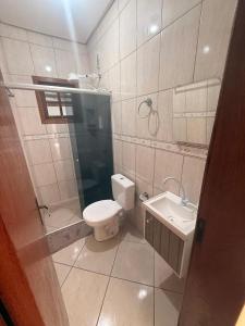 a bathroom with a toilet and a sink at Casa de hóspedes in Canoas