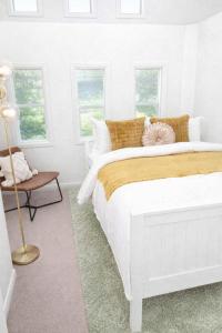 a white bedroom with a large bed and windows at The Gables Berry in Berry