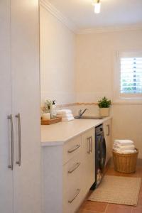 a kitchen with a sink and a washing machine at The Gables Berry in Berry +27 photos