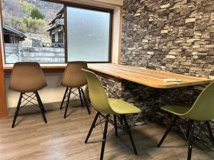 a table and chairs in a room with a stone wall at Seven base Yoshiumi in Imabari +19 photos