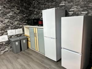 a kitchen with two refrigerators and two trash cans at Seven base Yoshiumi in Imabari