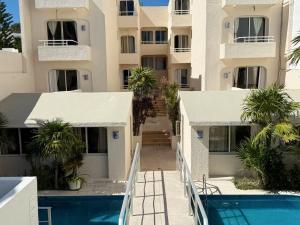an external view of a building with a swimming pool at Condohotel Luciana Deluxe Queen Oceanview Suite with Sofabed in Playa del Carmen