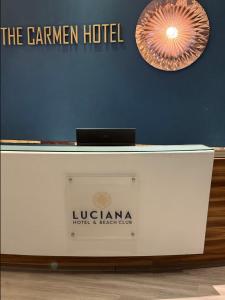 a white desk with a sign on a blue wall at Condohotel Luciana Deluxe Queen Oceanview Suite with Sofabed in Playa del Carmen +28 photos