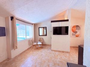 a living room with a flat screen tv on a wall at Condohotel Luciana Deluxe Queen Oceanview Suite with Sofabed in Playa del Carmen