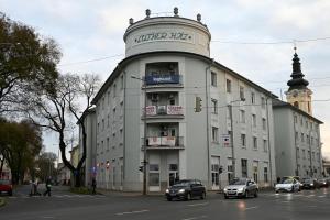 a large white building with a clock tower on a street at Palatini Apartman in Nyíregyháza
