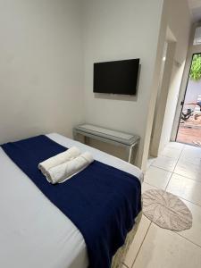a bedroom with a bed with two towels on it at Pousada brandt Ap 3 in Campo Grande