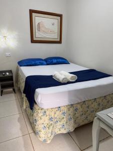 a bedroom with a bed with two towels on it at Pousada brandt Ap 3 in Campo Grande